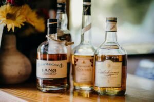 Close-up of premium whiskey and rum bottles displayed on a wooden surface.